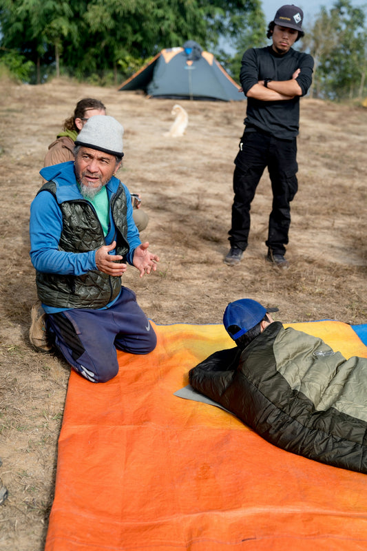 A man laying on top of a sleeping bag